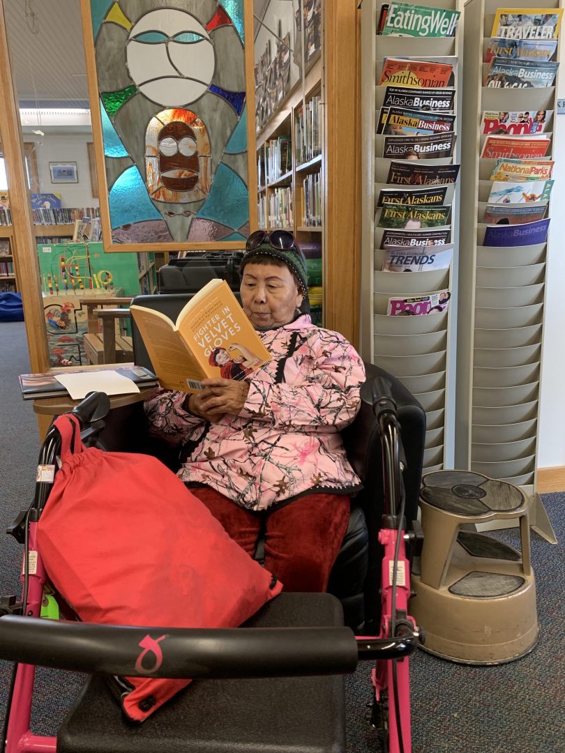 Alaskan Native elder reading Fighter in Velvet Gloves